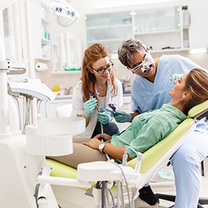 Dentist examining patient's teeth in treatment room
