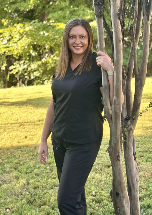 Dr. Justyna Laska next to a tree
