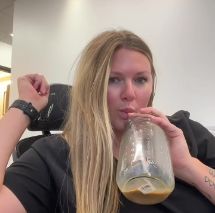 Blonde woman sitting and drinking chocolate milk out of jug