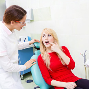 Patient pointing out dental problem to her dentist