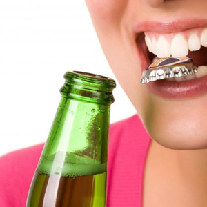 Woman removing bottlecap with her teeth