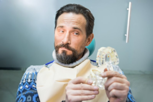 Man looking at a dental model and raising an eyebrow