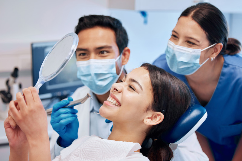 Patient smiling in the mirror after cosmetic dentistry